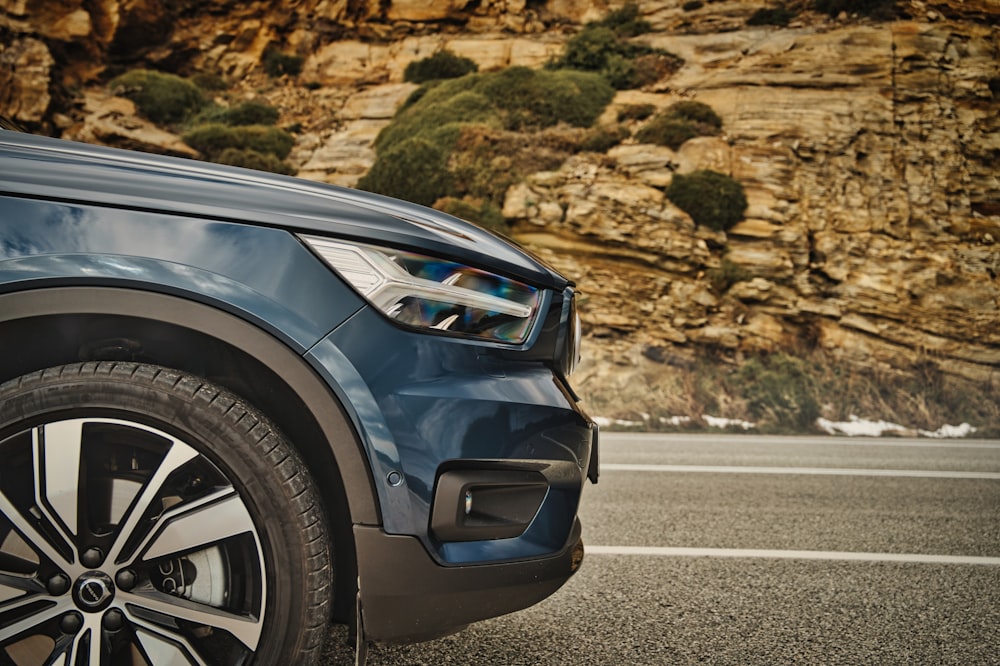 a close up of a car on a road with mountains in the background