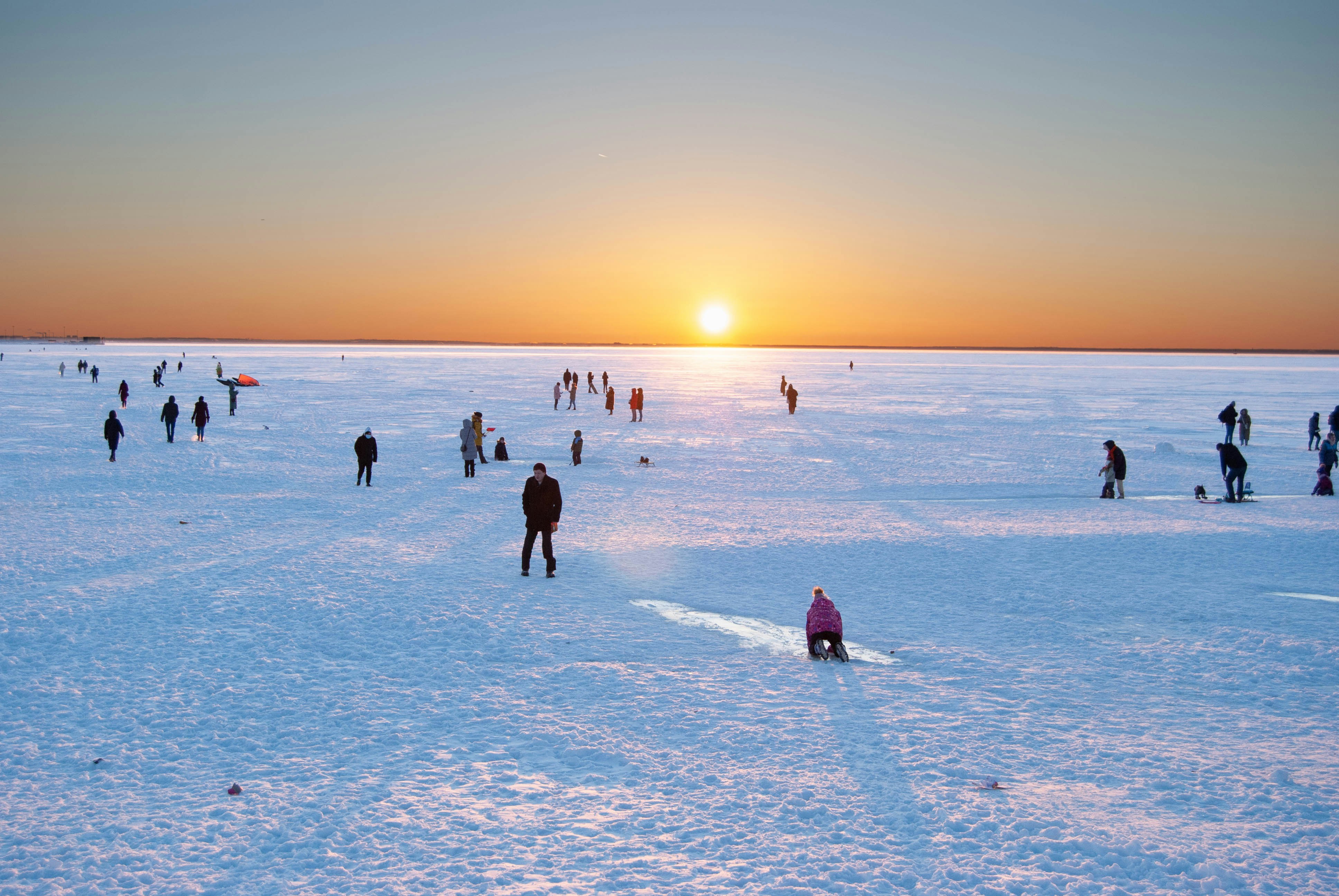 a group of people standing on top of a snow covered field
