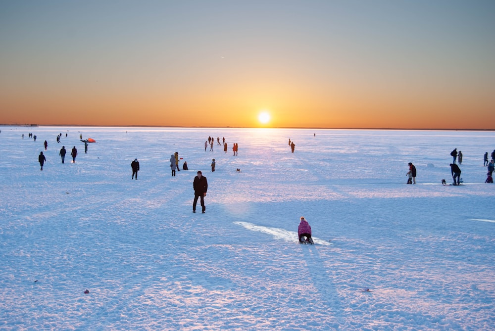 a group of people standing on top of a snow covered field