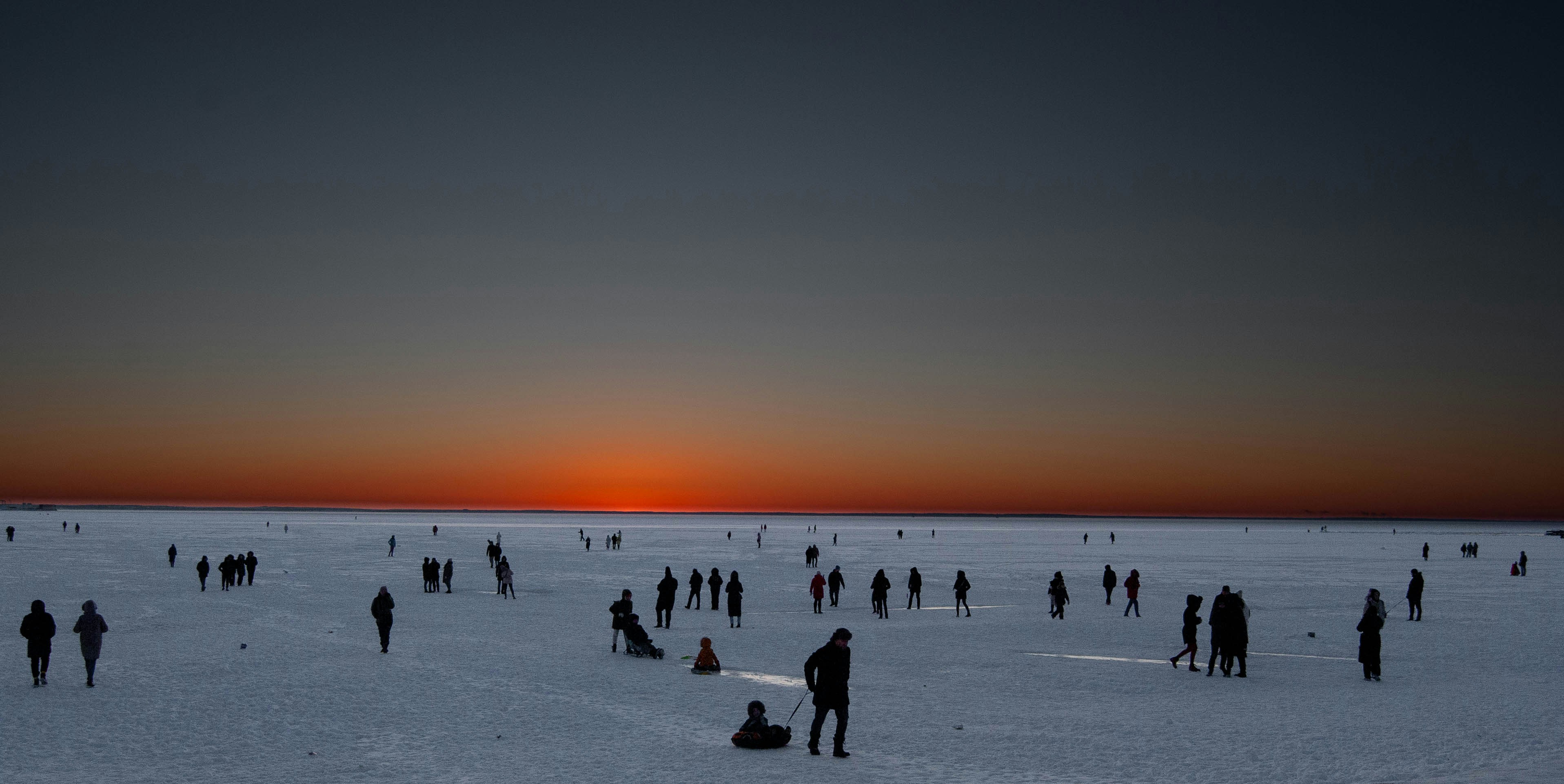 a group of people standing on top of a snow covered field