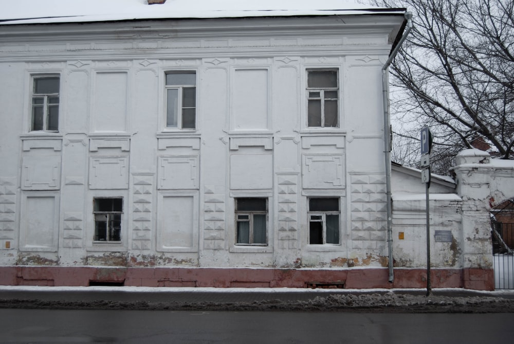 a white building with windows and a fence in front of it