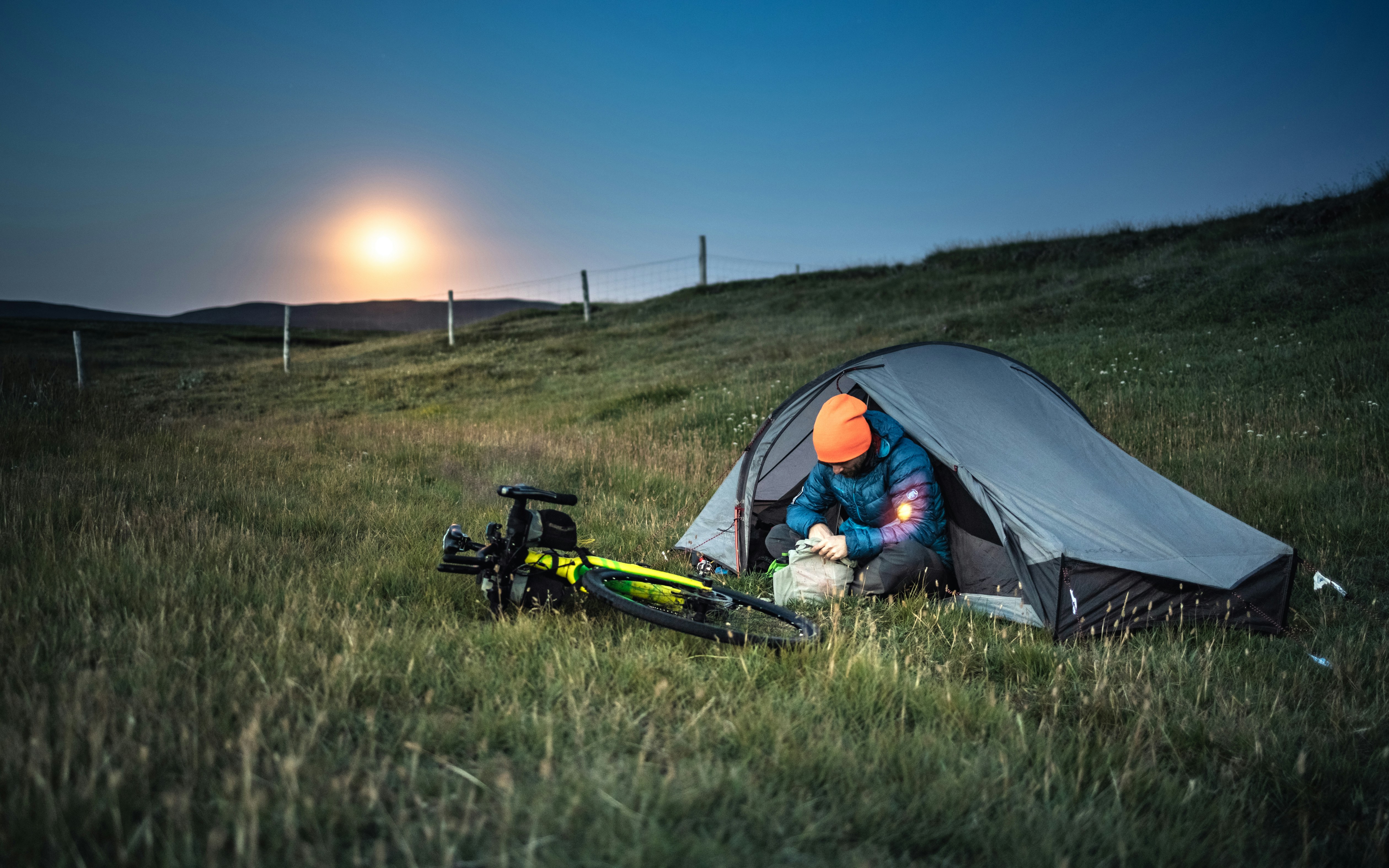 a person sitting in a tent next to a bike