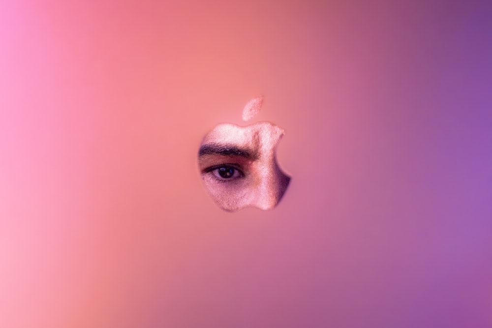a close up of an apple logo with a person's eye