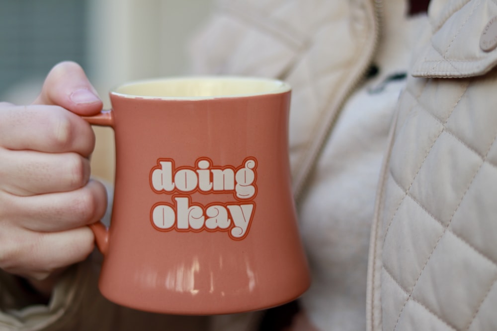 a close up of a person holding a coffee mug