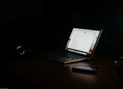 a laptop computer sitting on top of a wooden desk