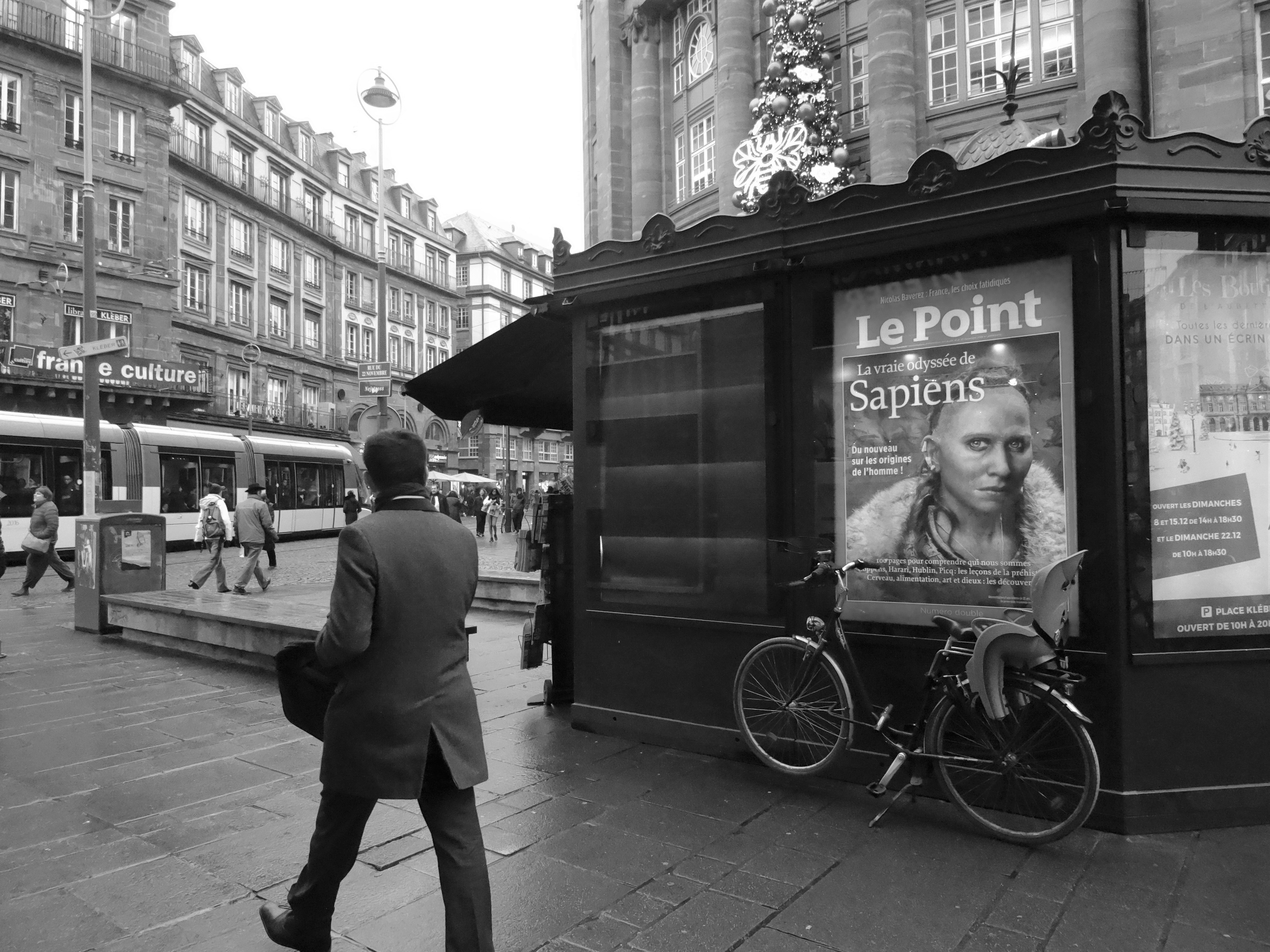 a man in a suit walking past a bus stop