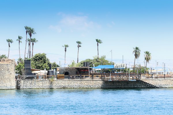A large body of water with palm trees in the background — Galilee & the Sea of Galilee, Israel