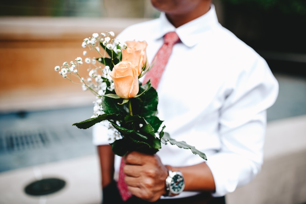 a man holding a bouquet of flowers in his hands