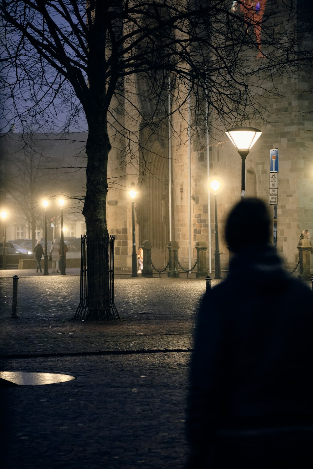 a person walking down a street at night