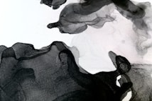 Abstract black and white ink wash art with flowing, organic shapes. The gradients and textures create a sense of movement and depth.