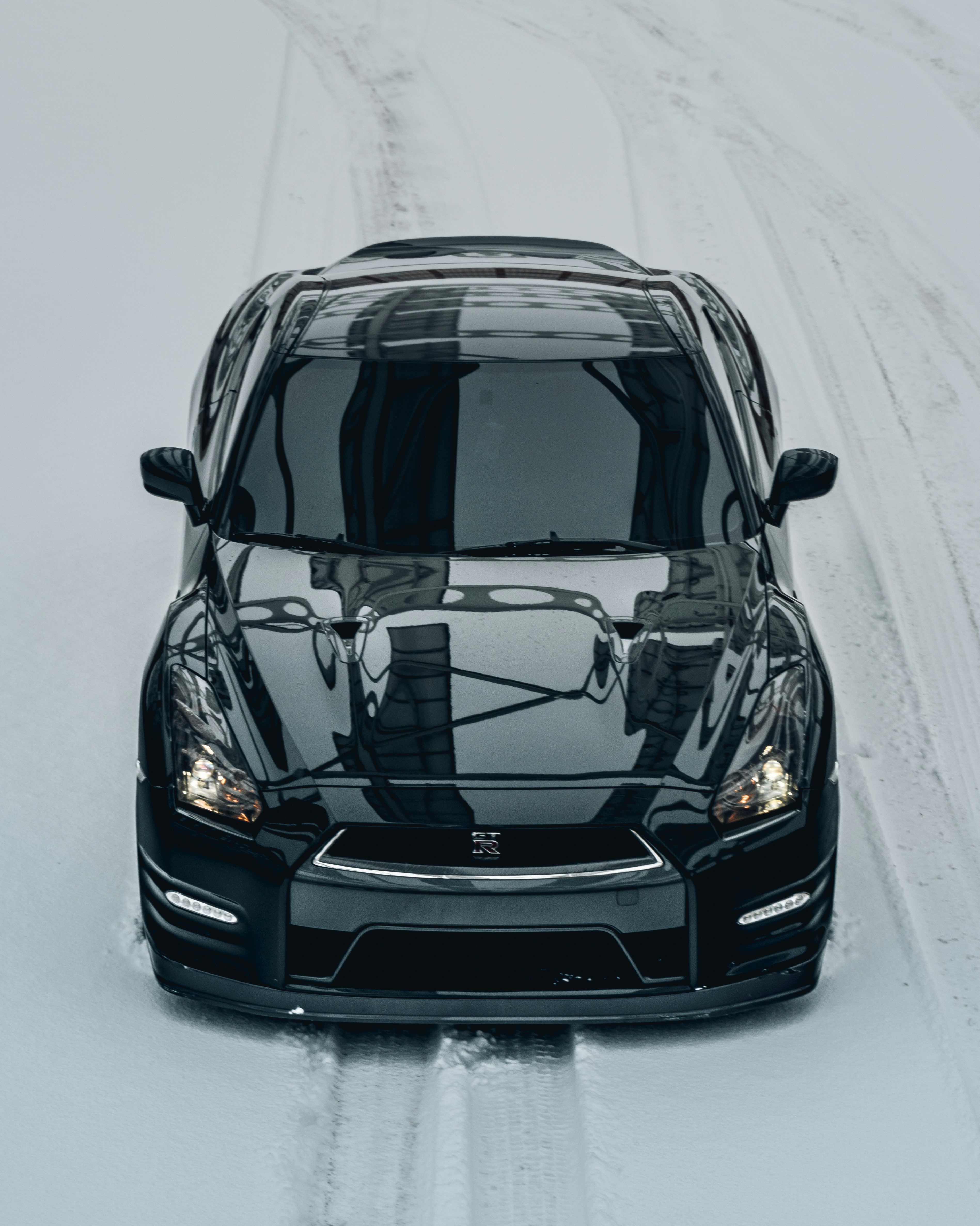 A black car driving down a snow covered road photo – Free Ia Image on ...