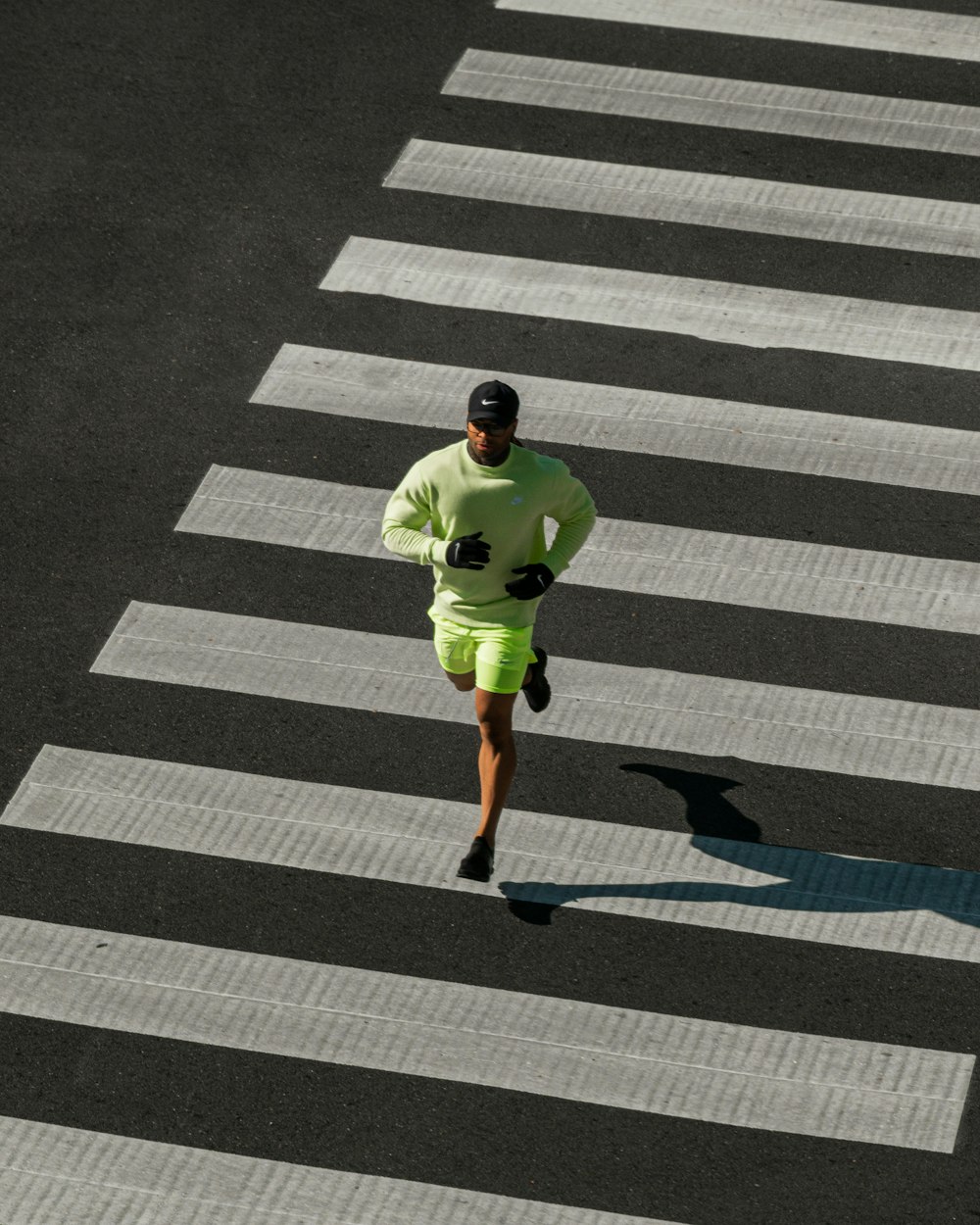 Un uomo in un vestito verde che attraversa una strada