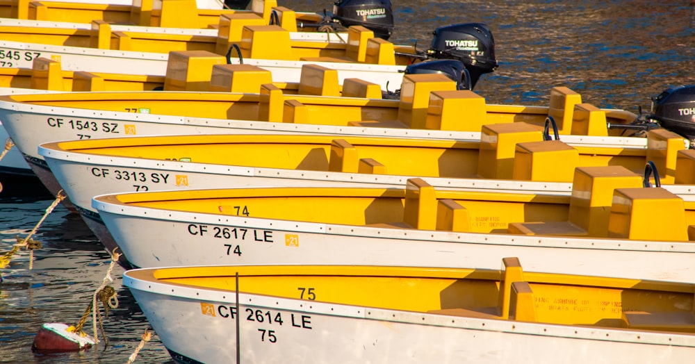 a row of yellow and white boats sitting next to each other