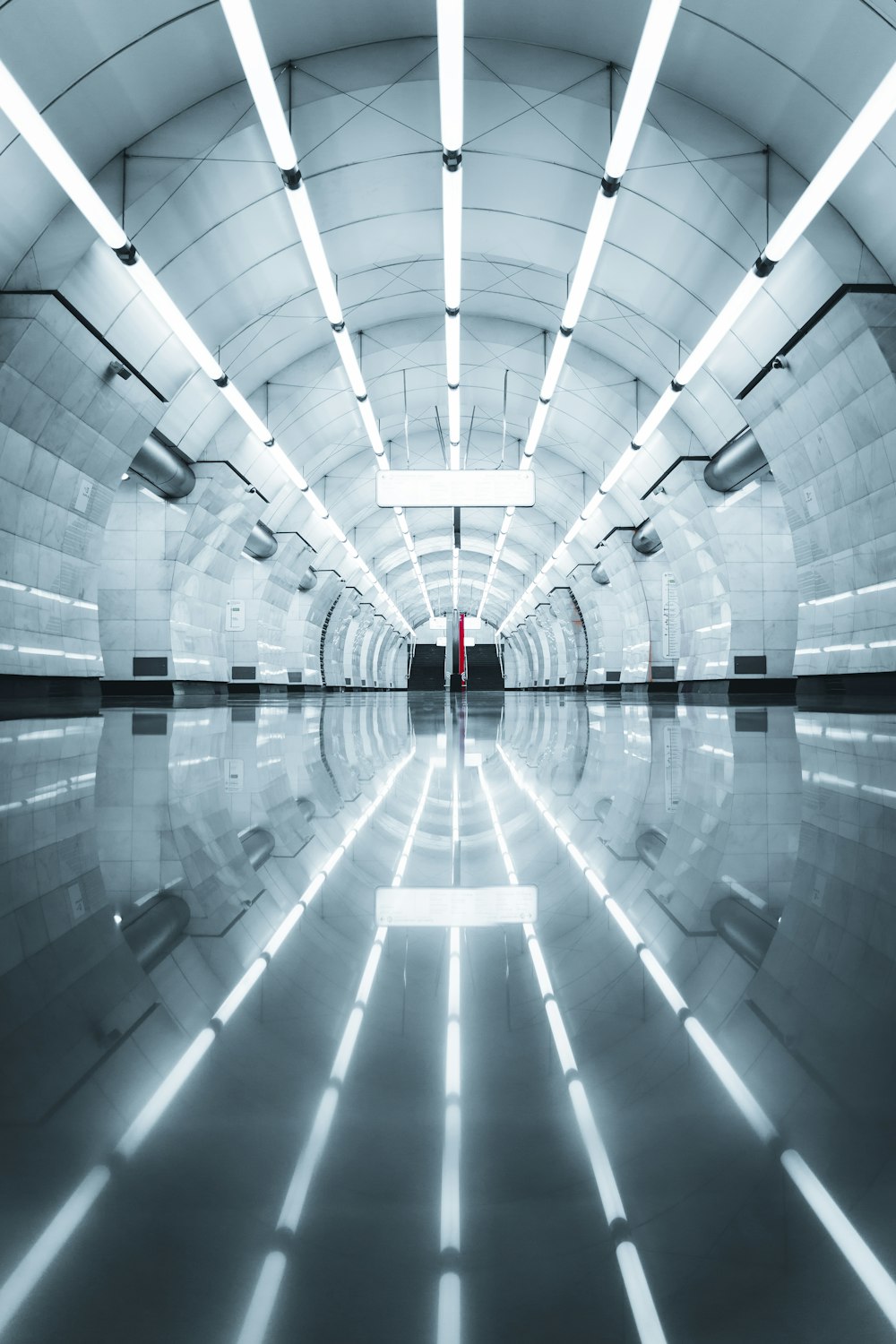 a long tunnel with a red door in the middle of it