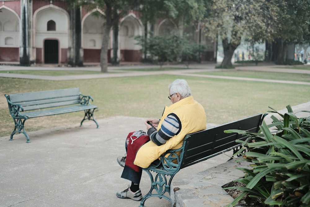 a man sitting on a bench in a park