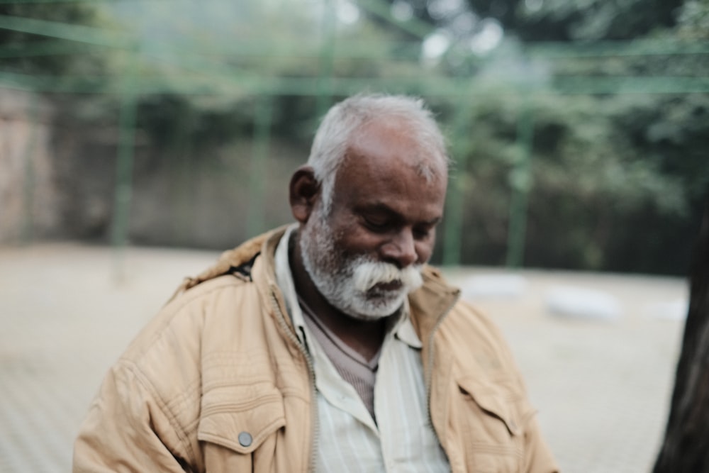 a man with a white beard wearing a tan jacket