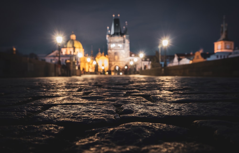 a city street at night with a clock tower in the background