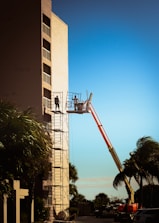 a man on a lift working on a building