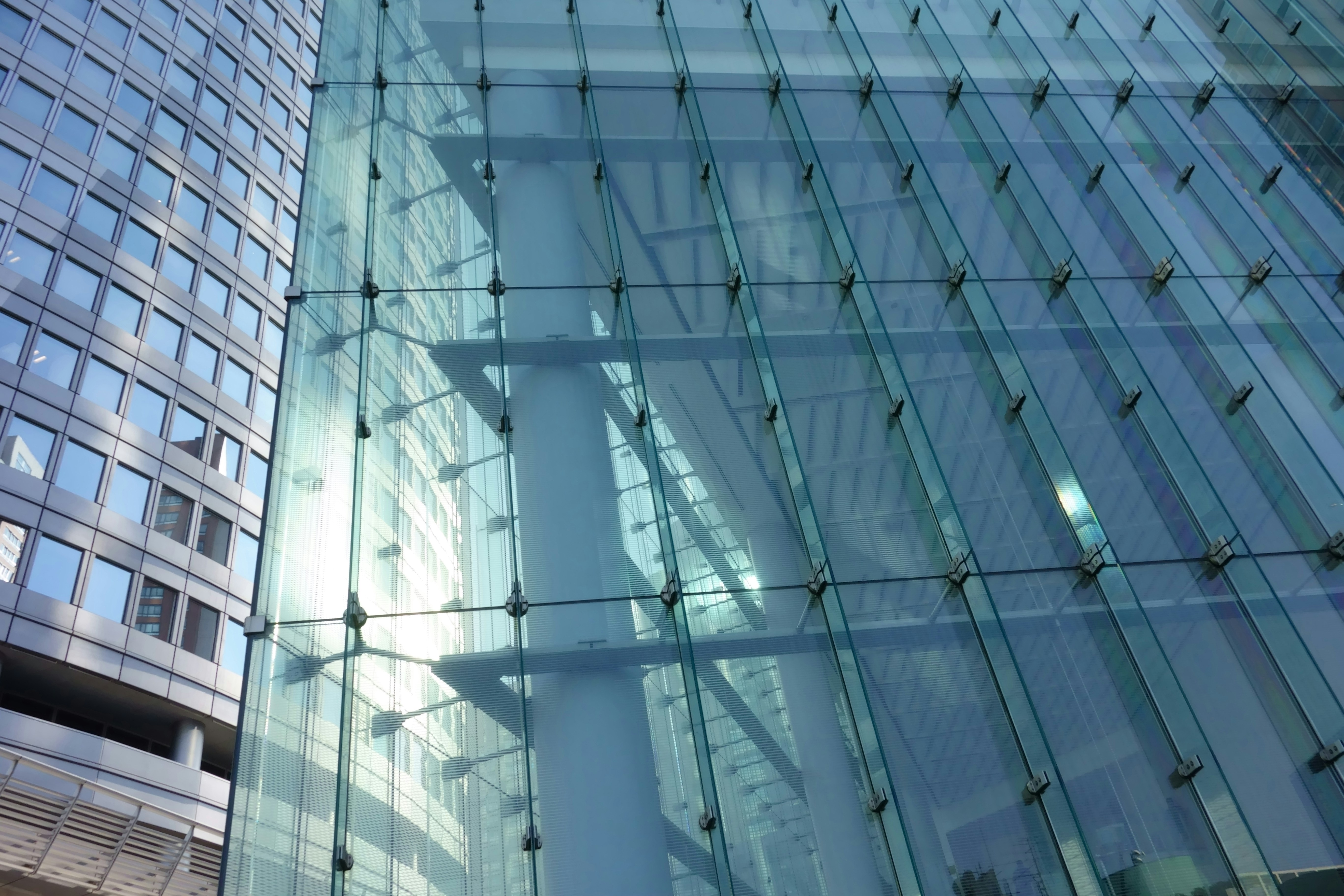 a tall glass building next to another tall building