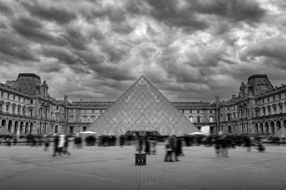 a black and white photo of a pyramid in a courtyard