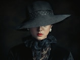 a woman wearing a black hat and scarf