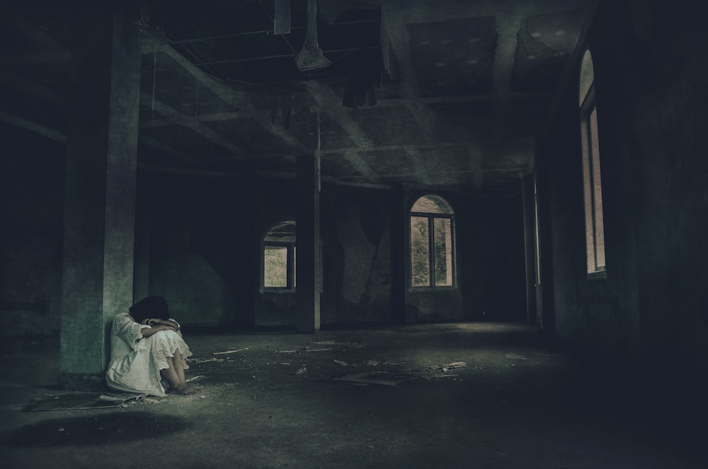 a person sitting on the floor in a dark room