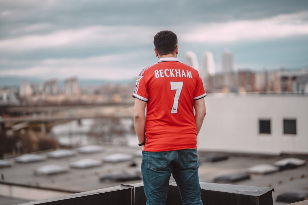 a man standing on top of a roof next to a building