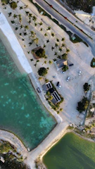 an aerial view of a parking lot next to a body of water