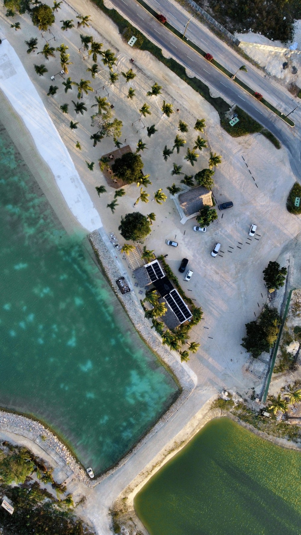 an aerial view of a parking lot next to a body of water