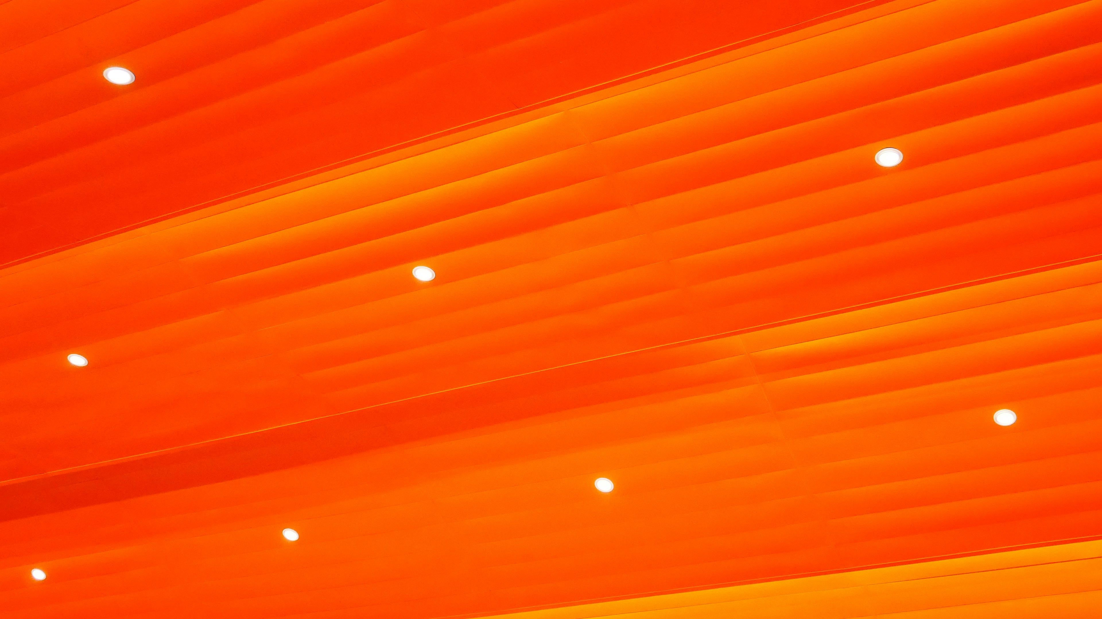 ein Raum mit orangefarbenen Lichtern und einer Uhr an der Wand