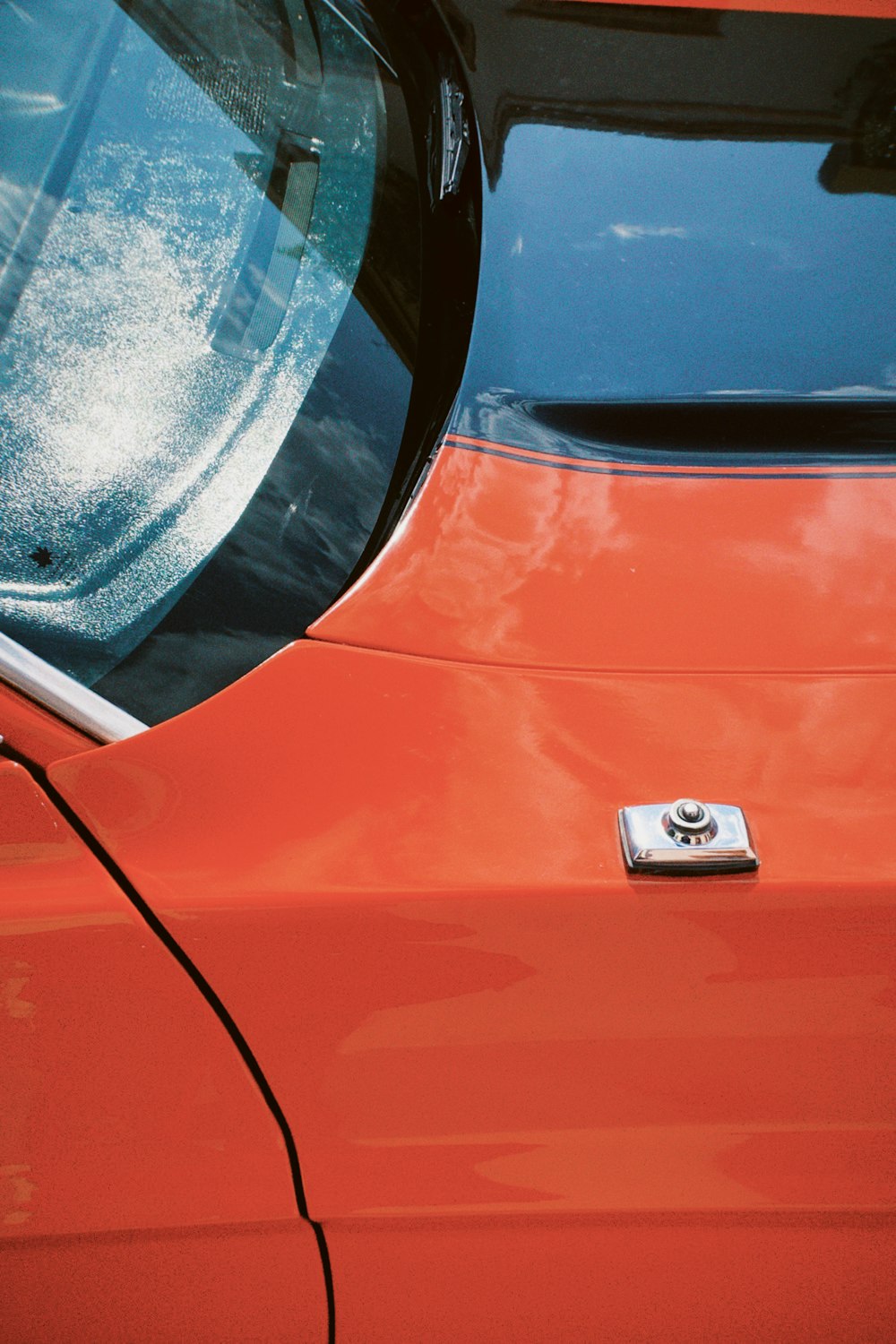 a close up of a red car with a badge on it