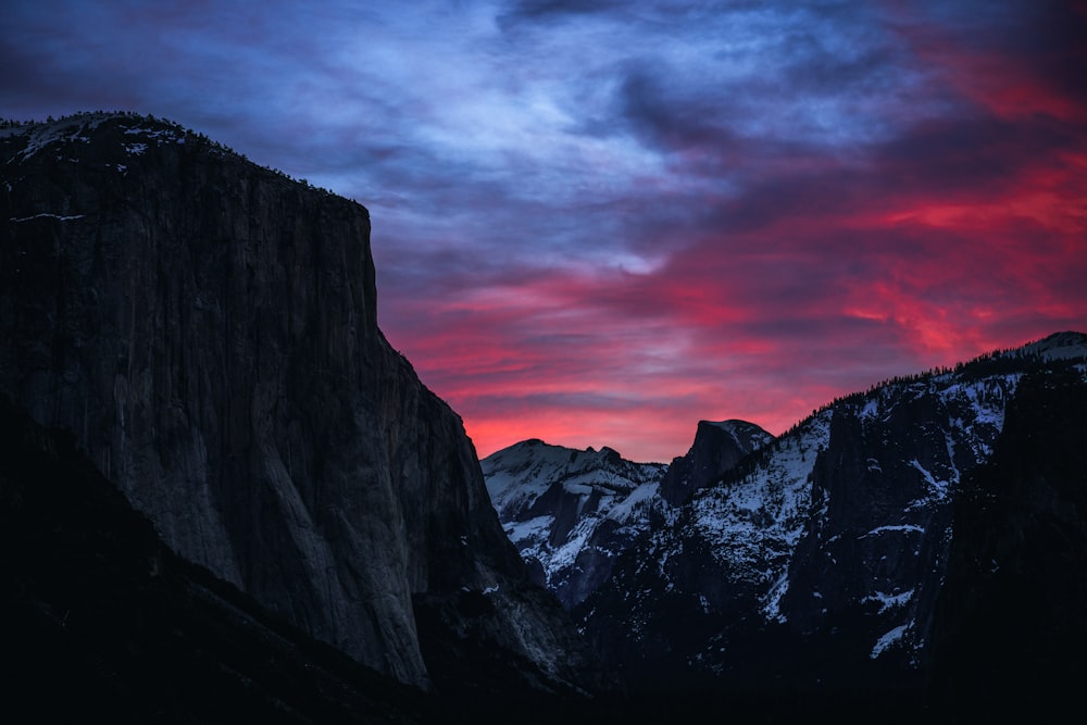 a mountain with a red sky in the background