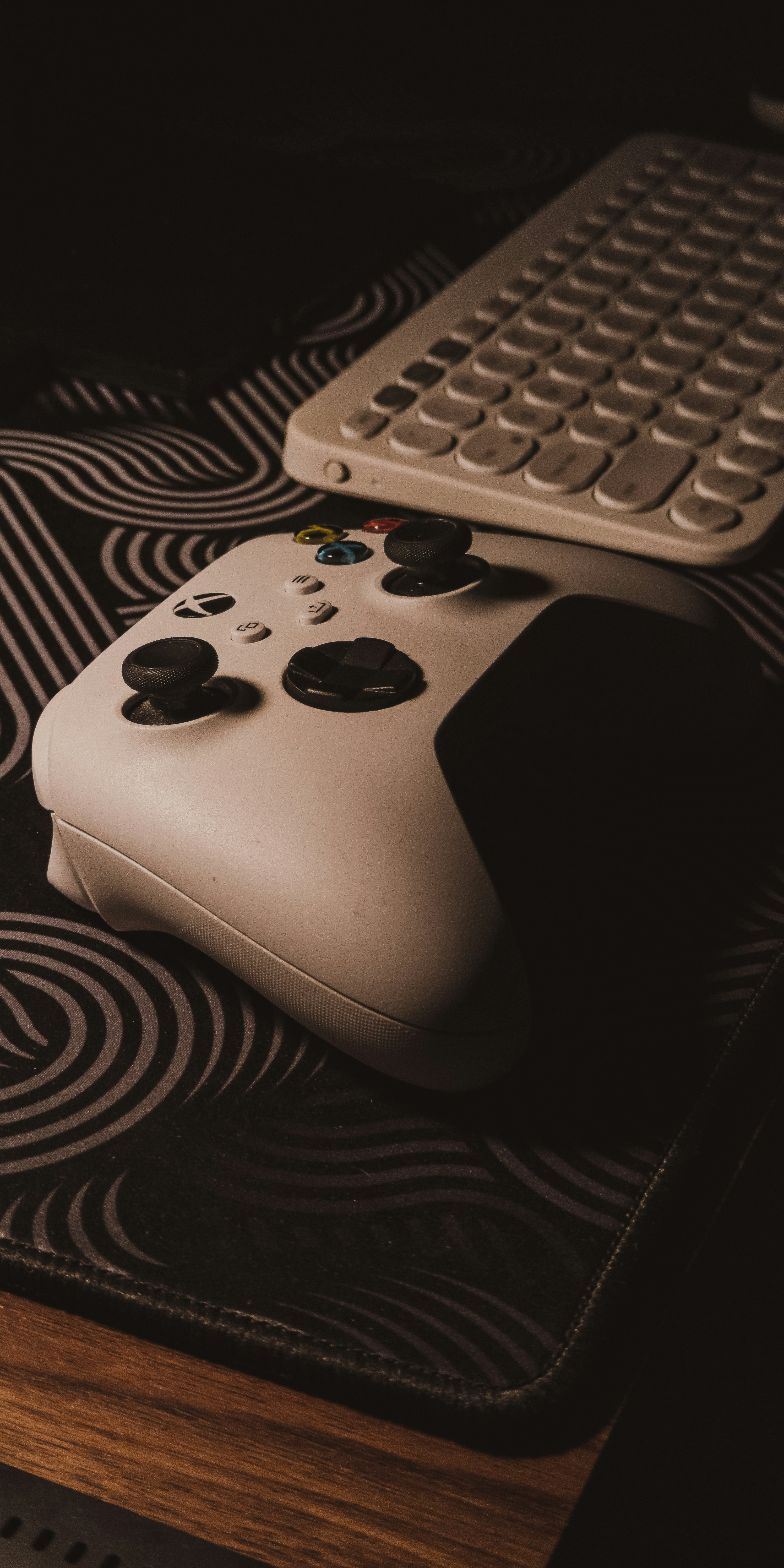 a white controller sitting on top of a table next to a keyboard