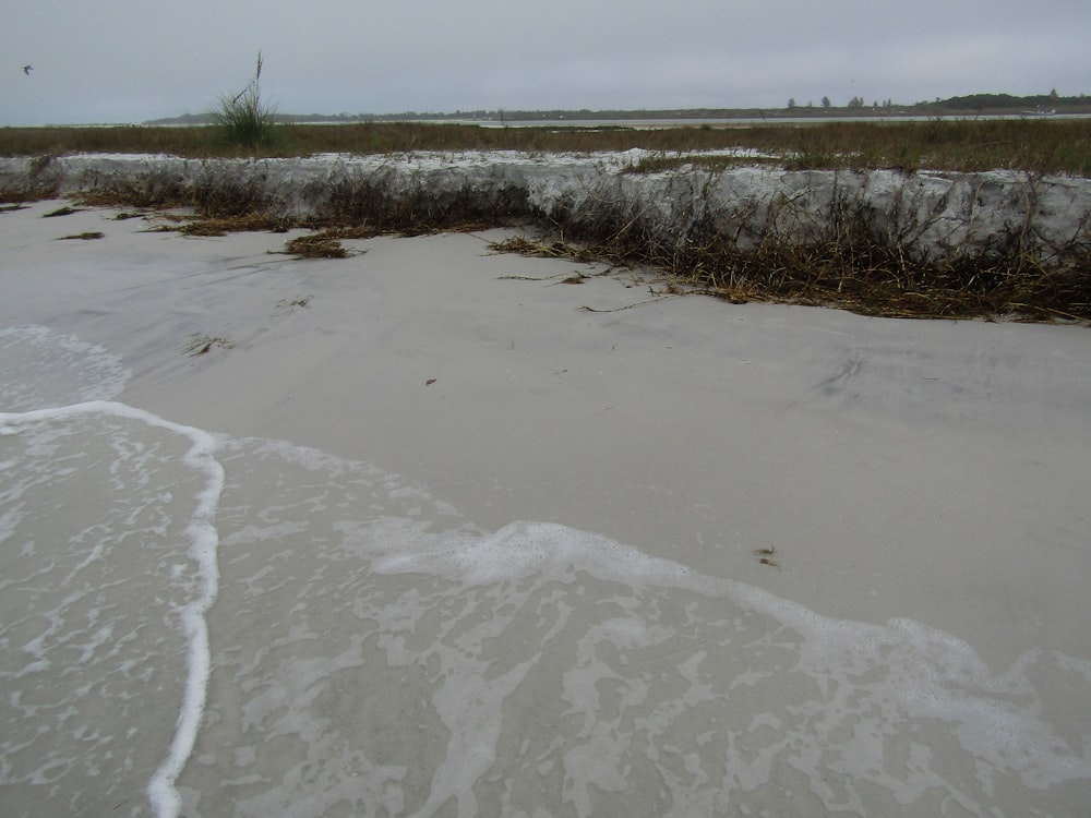 a sandy beach with waves coming in to shore