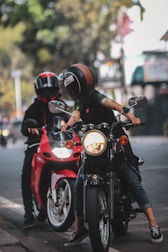 a man and a woman riding on the back of a red motorcycle