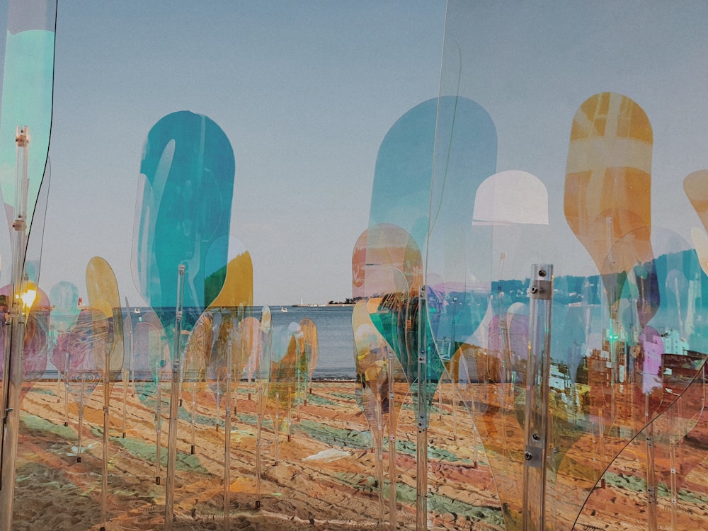 a group of glass sculptures sitting on top of a sandy beach