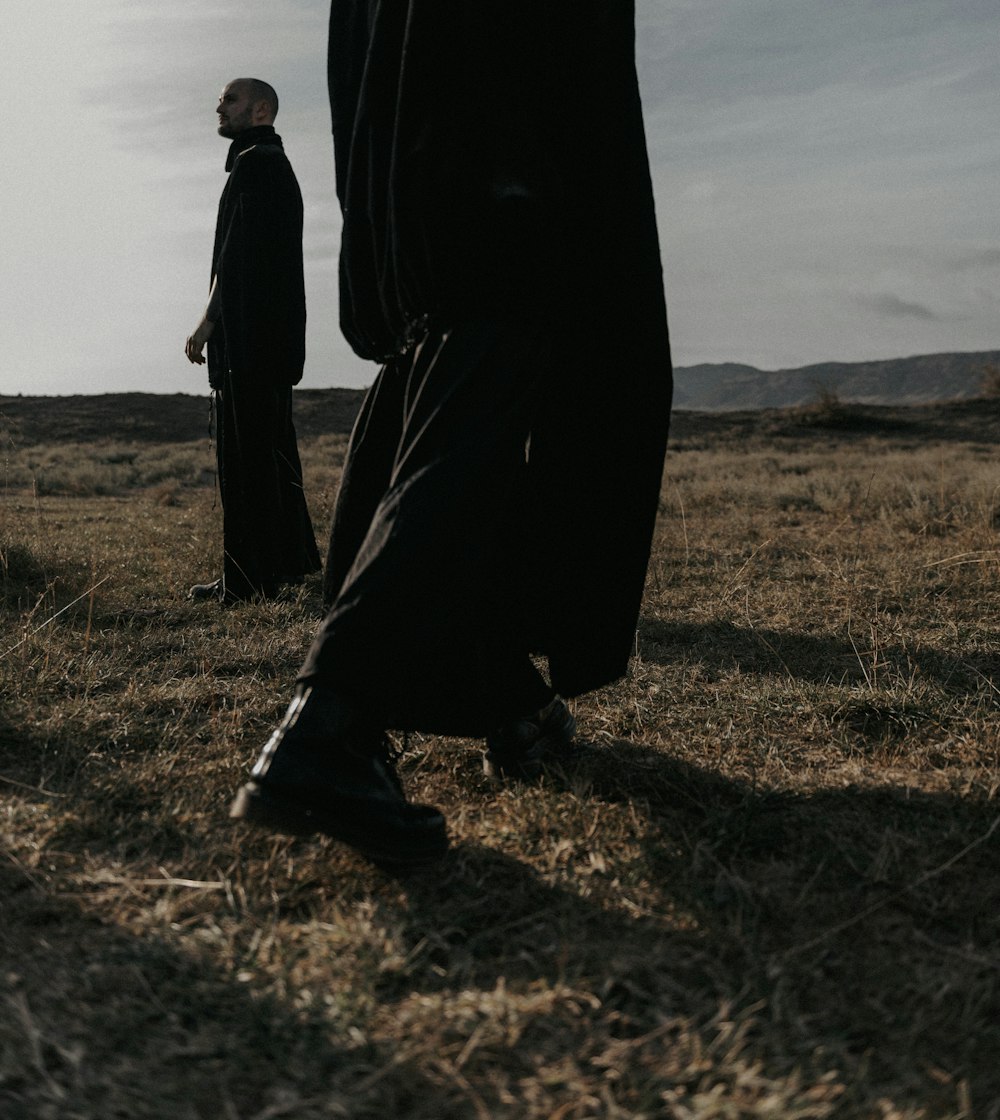 two men standing in the middle of a field