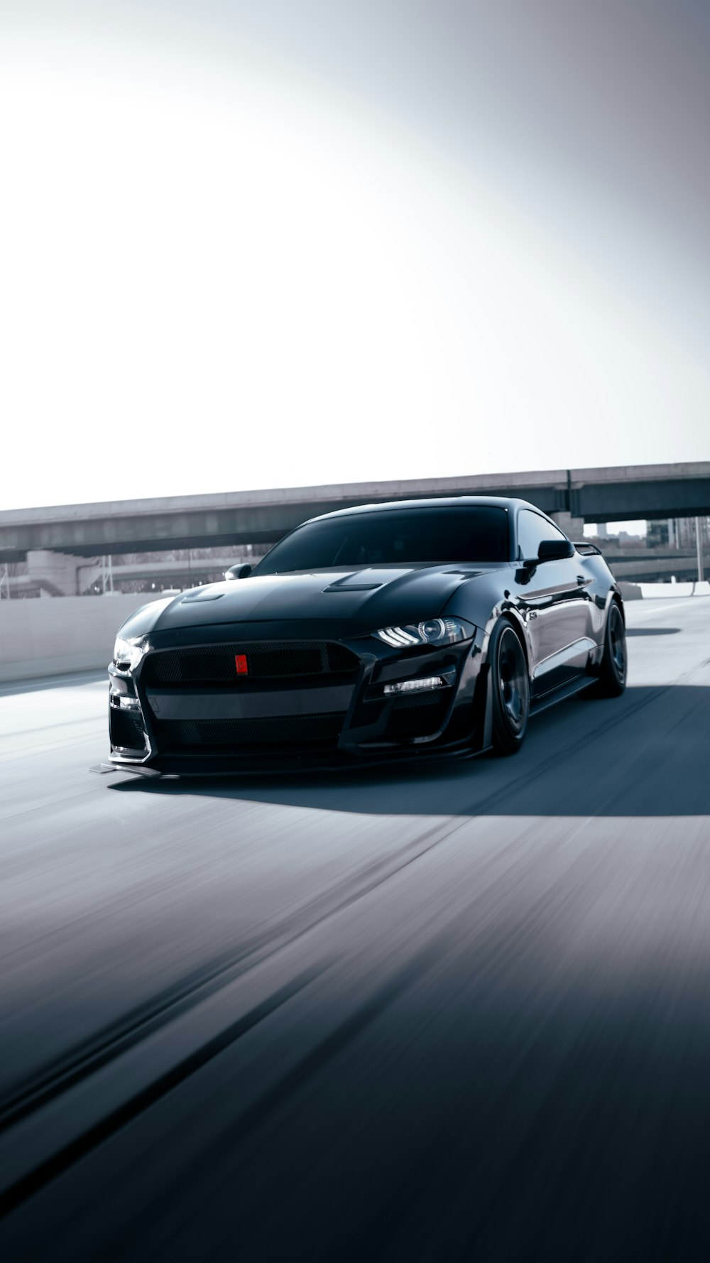 a black sports car driving down a highway