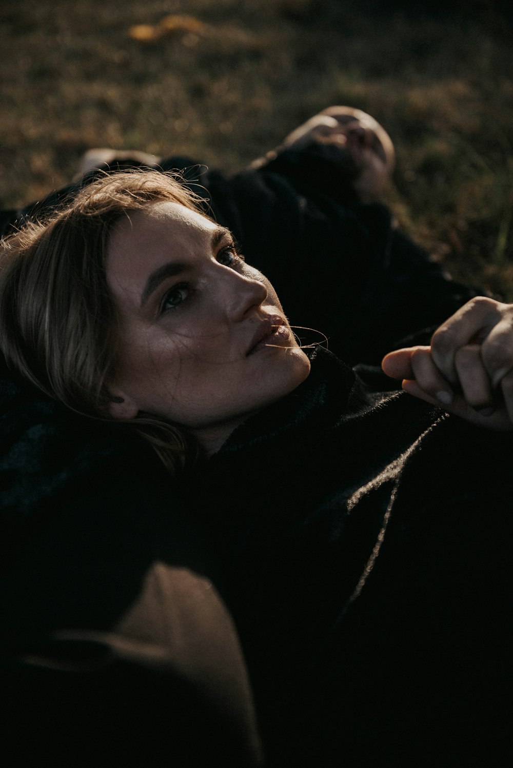 a woman laying on the ground in the grass