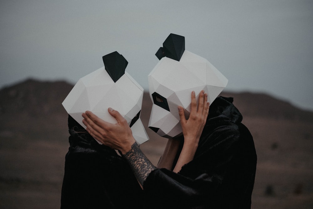 a man and a woman with paper masks covering their faces