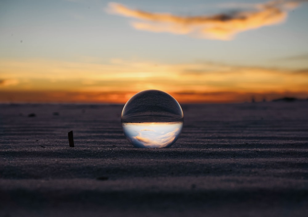 a large crystal ball sitting on top of a sandy beach