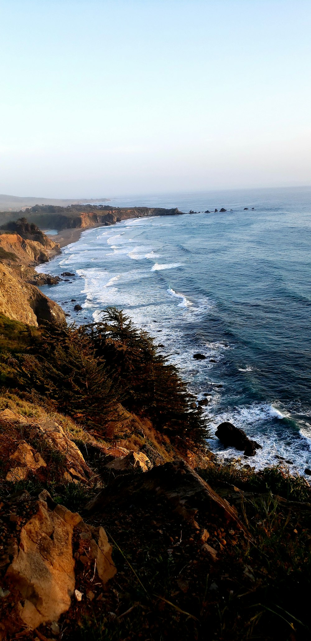 a view of the ocean from the top of a hill