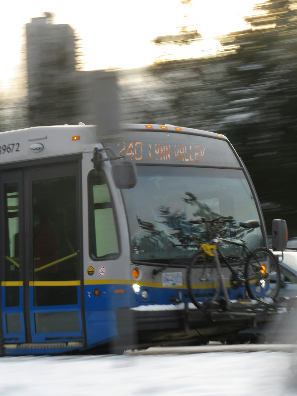 a blue and white bus driving down a street