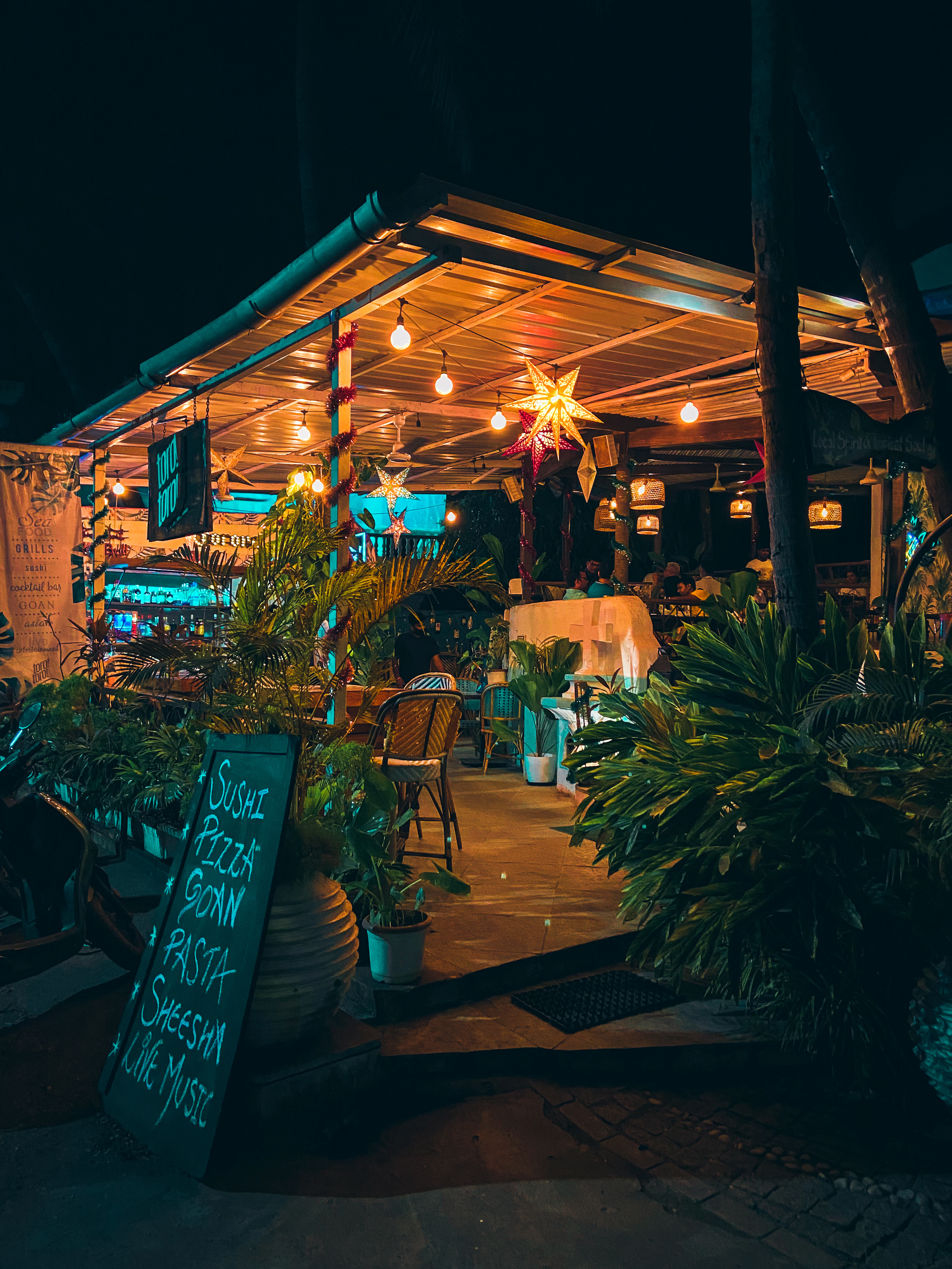 A restaurant with a lit sign at dusk