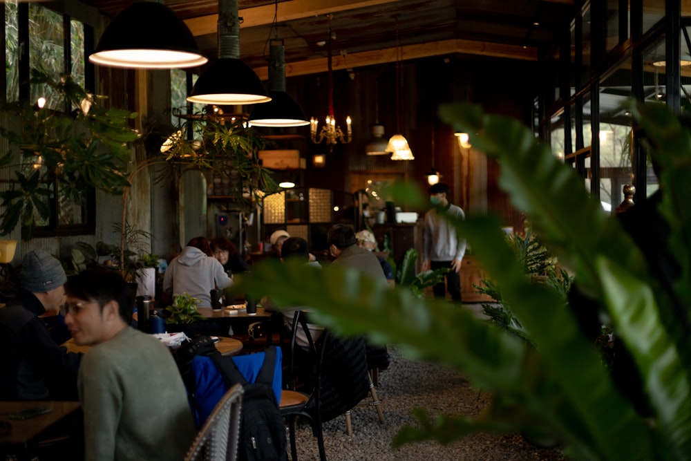 a group of people sitting at tables in a restaurant