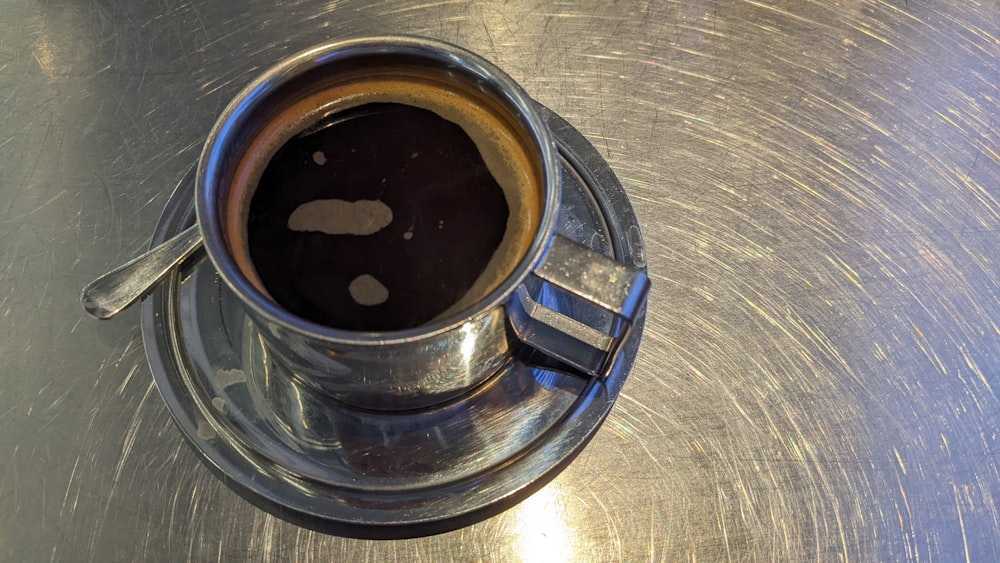 a cup of coffee sitting on top of a metal table