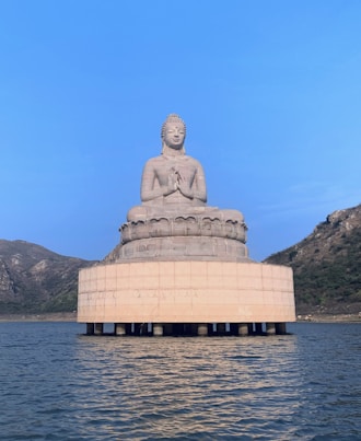 a large buddha statue sitting on top of a large body of water