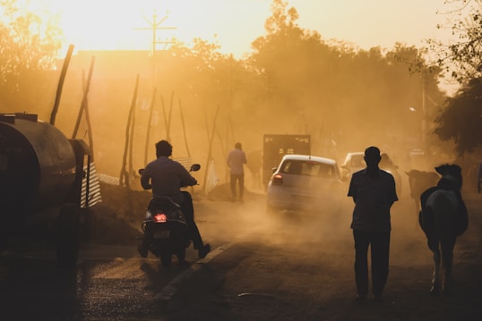 a group of people walking down a dirt road