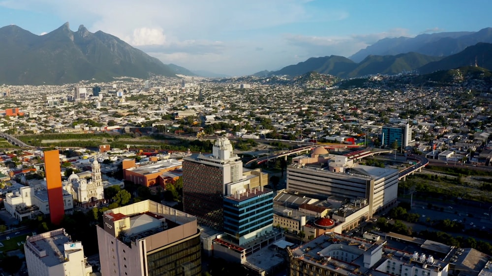 an aerial view of a city with mountains in the background