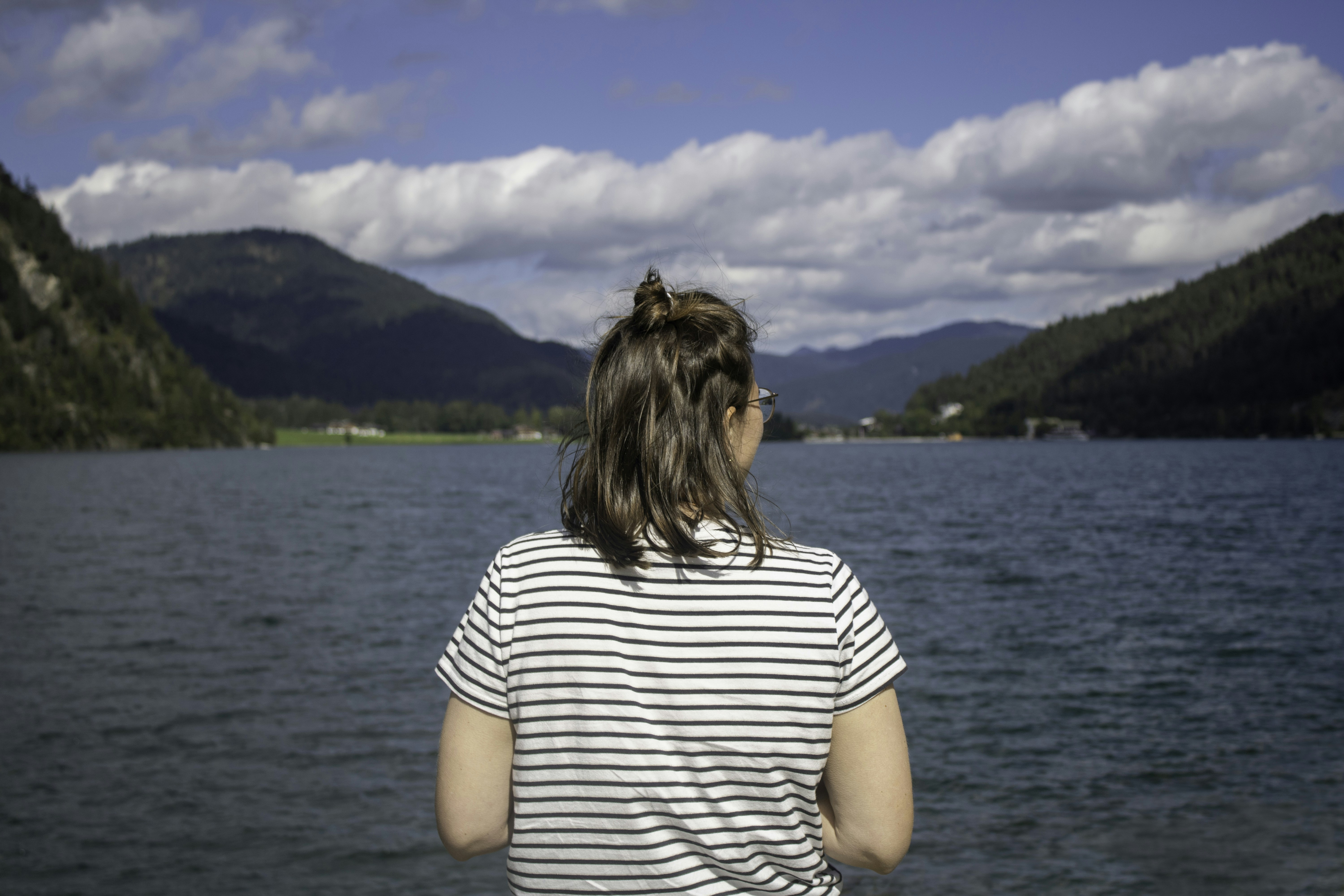 a woman standing in front of a body of water, 